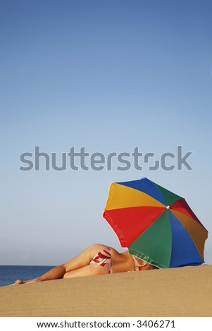 Low angle view of woman sunbathing on a beach