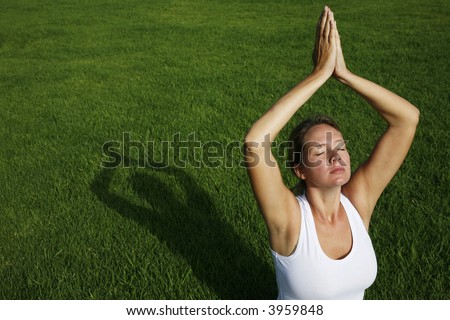 Woman in white in yoga position with green background