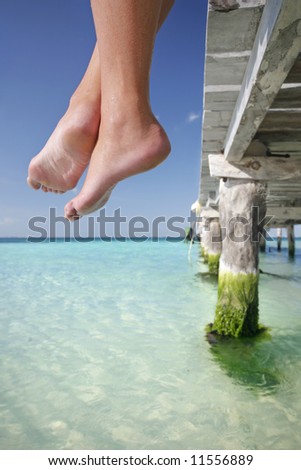 One of a large series. Great set of legs hanging over the edge of a tropical jetty.