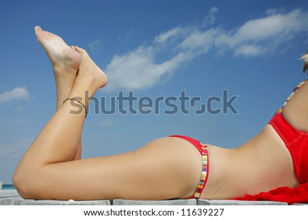 One of a large series. Woman in red bikini sunbathing on a tropical jetty