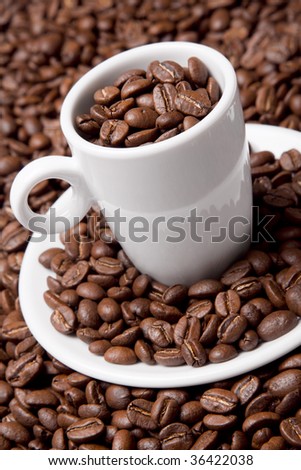 White coffee cup and saucer with roasted beans