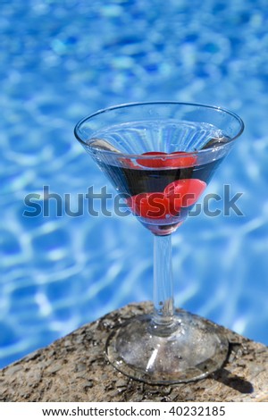 Poolside martini with red cherries and attractive blue water