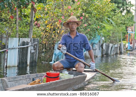 BANGKOK THAILAND - SEP 13: An unidentified man in boat. Bangkok\'s Flood on September 13, 2011 Soi Raminthra 109, Bangkok Thailand