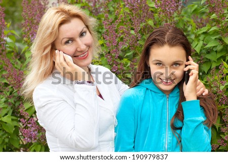 mother and daughter talk on phones