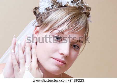 beautiful bride thoughtfully puts on an ear-ring