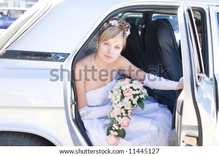 young bride siting in the car and looking for a groom