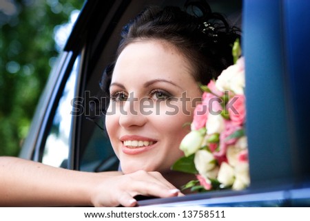 beautiful bride with flowers in the car