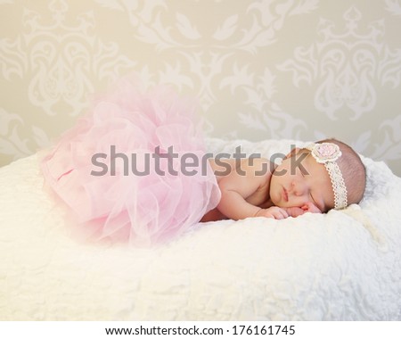 Tiny Sleeping Newborn Baby wearing pink tutu and pretty headband