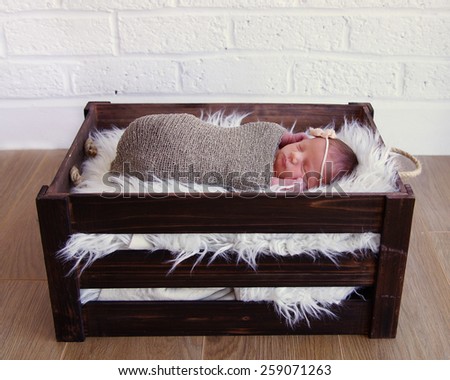 Newborn baby sleeping in vintage wooden crate