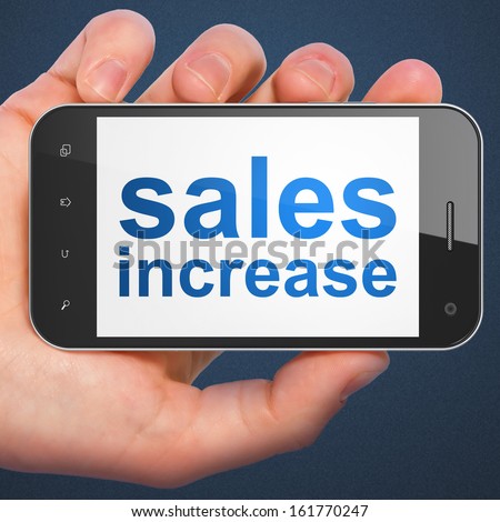 Advertising concept: hand holding smartphone with word Sales Increase on display. Mobile smart phone on Blue background, 3d render