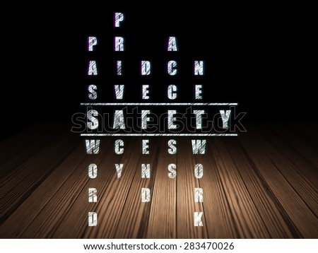 Safety concept: Glowing word Safety in solving Crossword Puzzle in grunge dark room with Wooden Floor, black background, 3d render