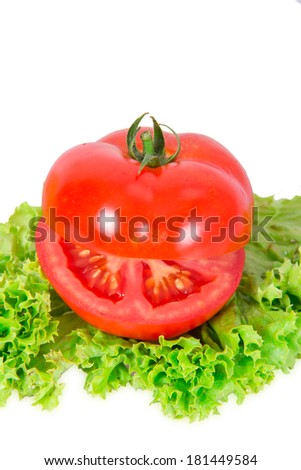 Red tomato lying on a piece of lettuce on white background