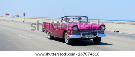 Havana, CUBA - March 19, 2015: A pink vintage Fairlane car cruising on the Malecon promenade in Havana, Cuba