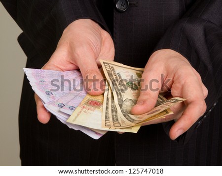 hand of a businessman in a suit holding a money