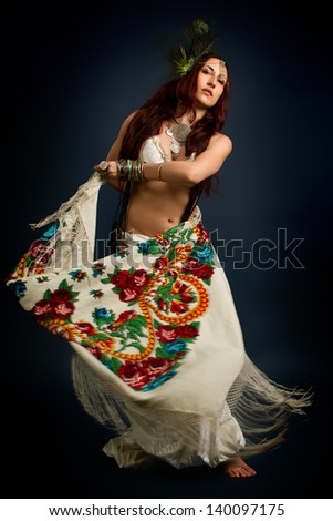 Performance. Young attractive retro model in old-fashioned wild clothing dancing. Tribe. Tattoo. Native savage woman