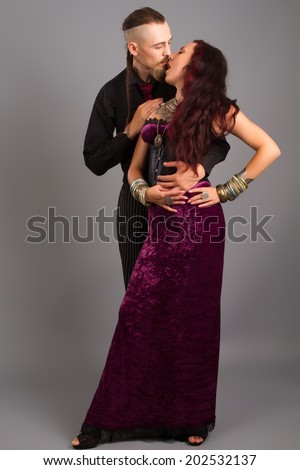 Portrait of young couple in love posing at studio dressed in classic clothe