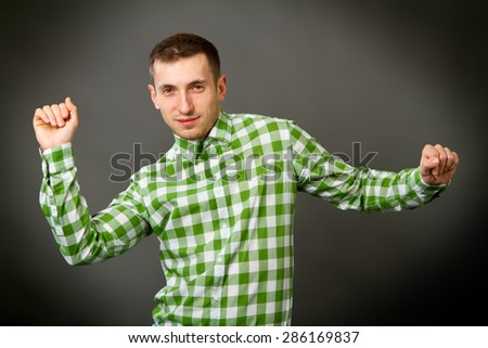 young guy in a checkered shirt on a gray background