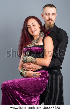 Portrait of young couple in love posing at studio dressed in classic clothe