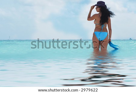 beautiful brunette walking in the sea watching ocean
