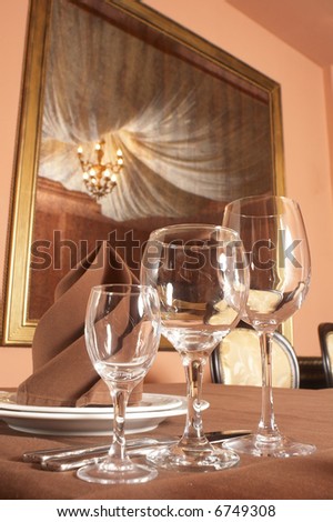 Restaurant interior. Table setting and the old mirror on background