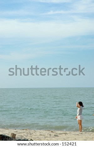 Chinese girl peering into the distance on a Penang beach