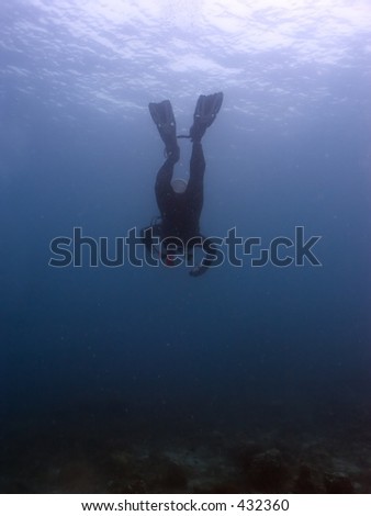 Scuba diver diving head first into the ocean