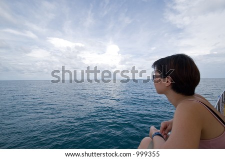 Asian lady aboard a dive boat, looking out into the open ocean