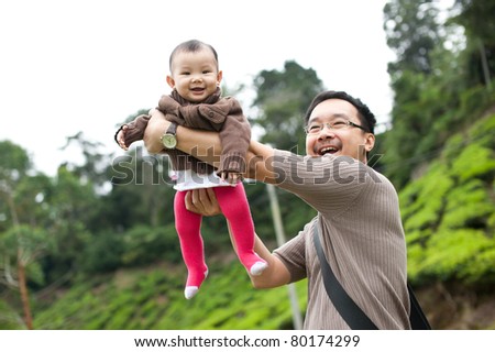 Asian father playing with her 7 month old baby girl