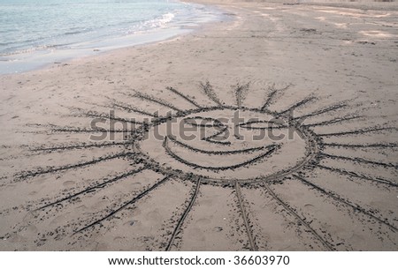 Smiling sun shape drawn along the beach