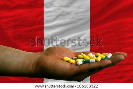 man holding capsules in front of complete wavy national flag of peru symbolizing health, medicine, cure, vitamins and healthy life
