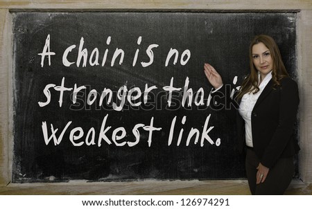 Successful, beautiful and confident woman showing A chain is no stronger than its weakest link on blackboard