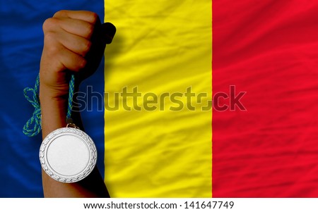 Holding silver medal for sport and national flag of  chad