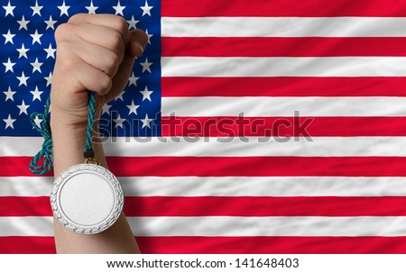 Holding silver medal for sport and national flag of us