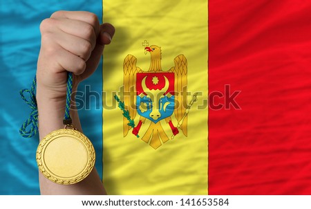 Winner holding gold medal for sport and national flag of moldova