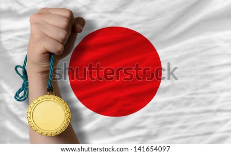 Winner holding gold medal for sport and national flag of japan