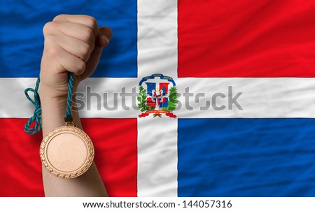 Holding bronze medal for sport and national flag of dominican