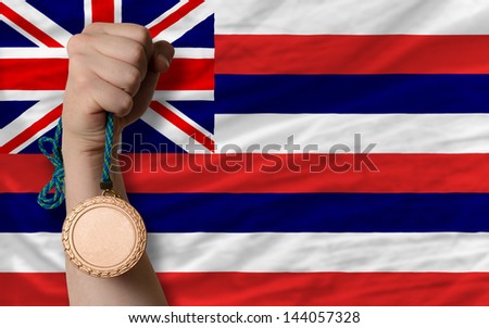 Holding bronze medal for sport and flag of us state of hawaii