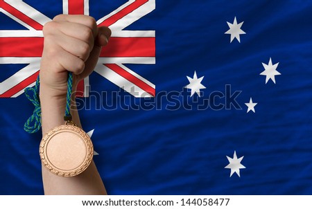 Holding bronze medal for sport and national flag of australia