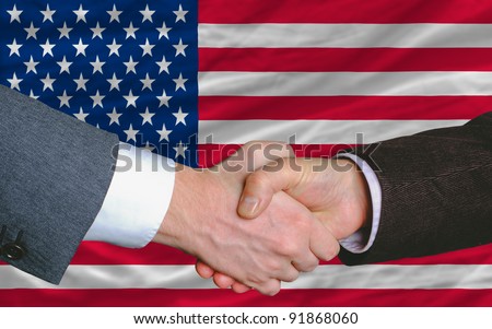 two businessmen shaking hands after good business investment  agreement in america, in front of flag