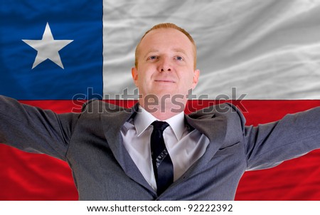 joyful investor spreading arms after good business investment in chile, in front of flag