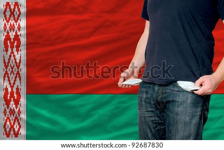 poor man showing empty pockets in front of belarus flag