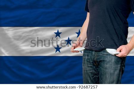 poor man showing empty pockets in front of honduras flag