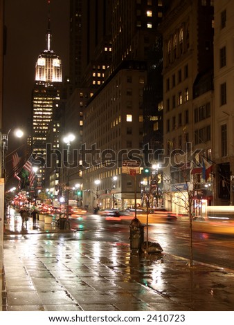 5th avenue and Empire State building by night under the rain, New York