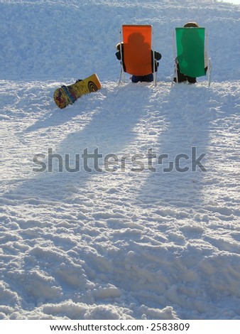 Snowboarders relaxing in the sun after a long day on the snow