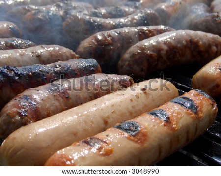 Sausages and wursts cooking on an outdoor grill