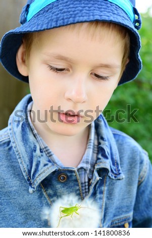 Cute five year old boy with grasshopper