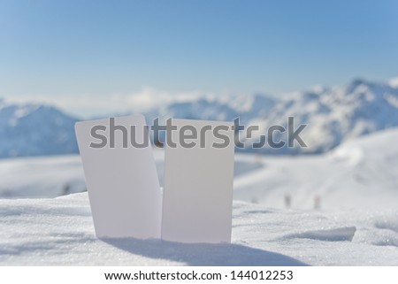 Two blank winter sport ski pass tickets with scenic background. Concept to illustrate winter sport admission fee