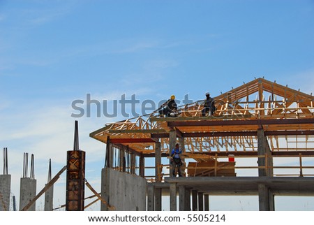 Elegant Beachfront Home Under Construction with Workers on Rafters
