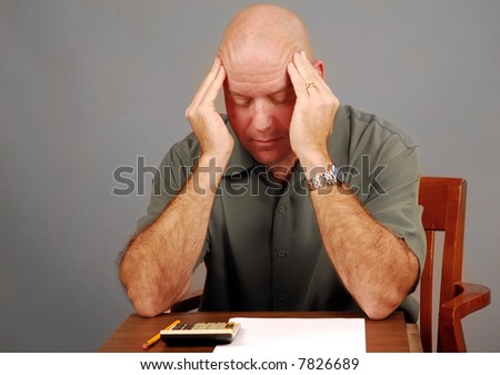 Middle Aged Man Looking Stressed Over Calculator