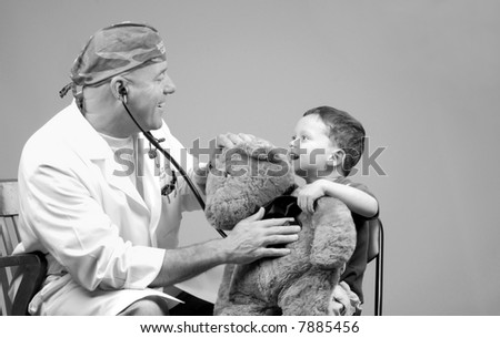 Family Physician Using Stethoscope on Young Boy\'s Bear